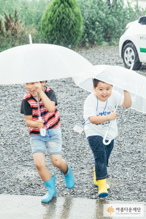 우산을 쓰고 걸어가는 아이들