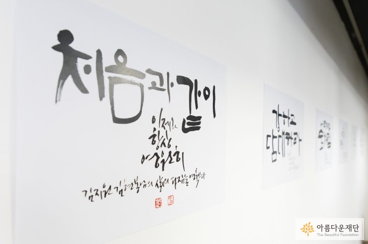 강병인 작가가 쓴 가훈이 프린트되어 벽에 붙어 있다