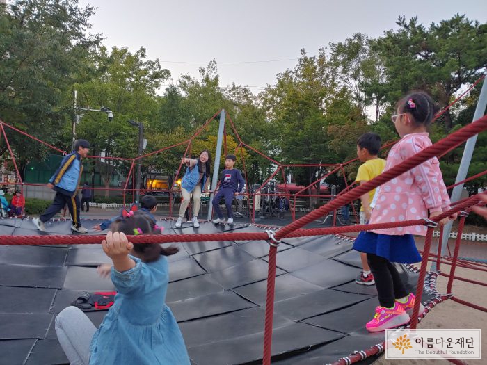 청소년들이 구로리어린이공원에서 아이들과 놀이를 하고 있습니다.