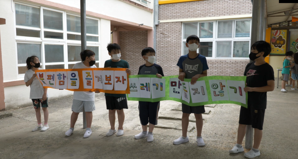 여수남초등학교 쓰레기 줄이기 캠페인을 위해 팻말을 들고 서있는 초등학생들