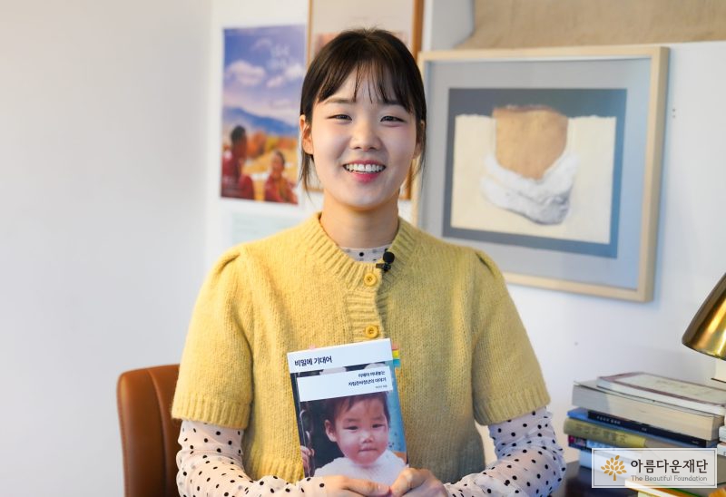 허진이 캠페이너가 책 <비밀에 기대어>를 들고 있다