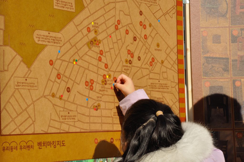 어린아이가 스티커를 지도 위에 붙이고 있다.
