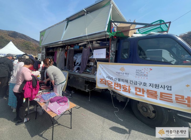트럭 앞에 사람들이 서있다