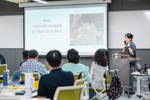 교육 강의자가 마이크를 잡고 말하고 있다.
