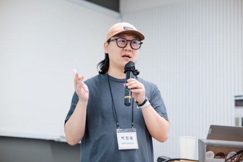 교육 강의자가 마이크를 잡고 말하고 있다.