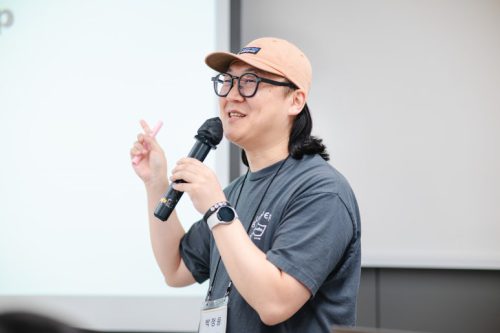 교육 강의자가 마이크를 잡고 말하고 있다.
