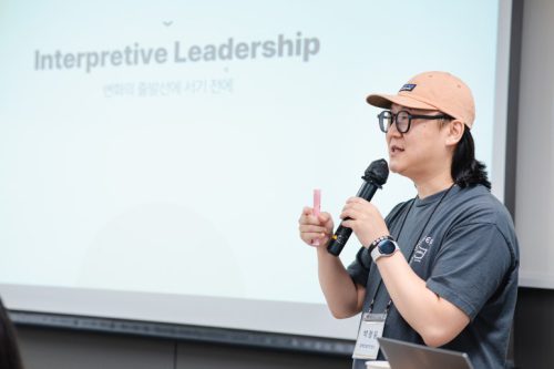 교육 강의자가 마이크를 잡고 말하고 있다.