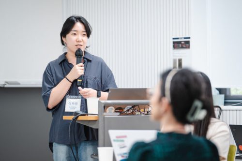 교육 강의자가 마이크를 잡고 말하고 있다.