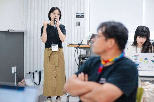 교육 강의자가 마이크를 잡고 말하고 있다.