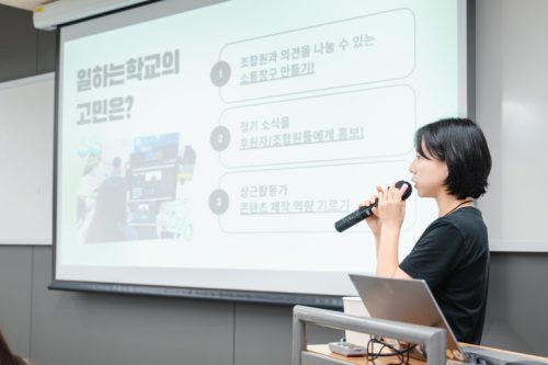 교육 강의자가 마이크를 잡고 말하고 있다.