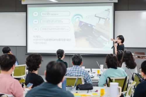 교육 강의자가 마이크를 잡고 말하고 있다.
