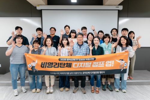 지원사업 참여자가 다같이 현수막을 듣고 환하게 웃고 있다.