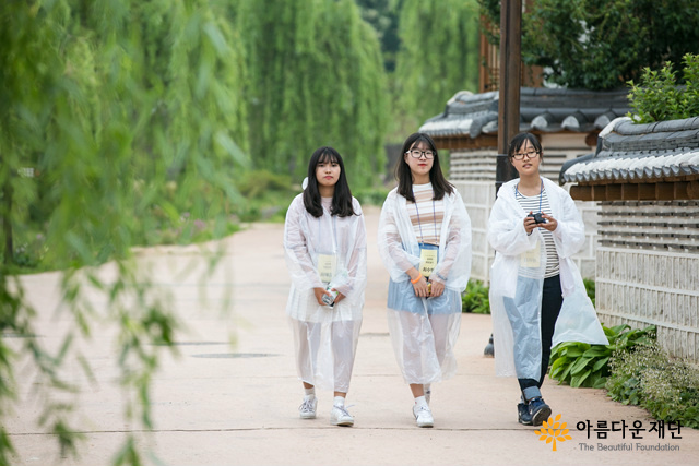 세명의 소녀가 사진 촬영을 하러 걷는 중이다