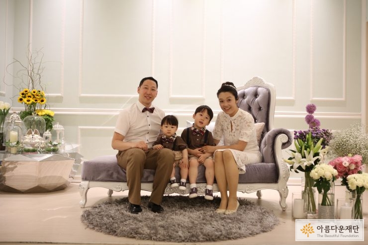 가족사진을 찍기 위해 의자에 앉아있는 가족