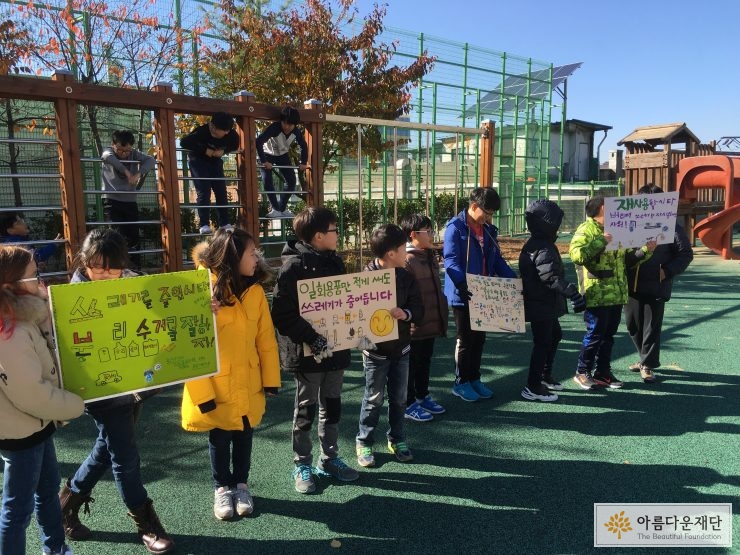 교내에서 쓰레기를 줄이자는 캠페인을 하고 있는 아이들